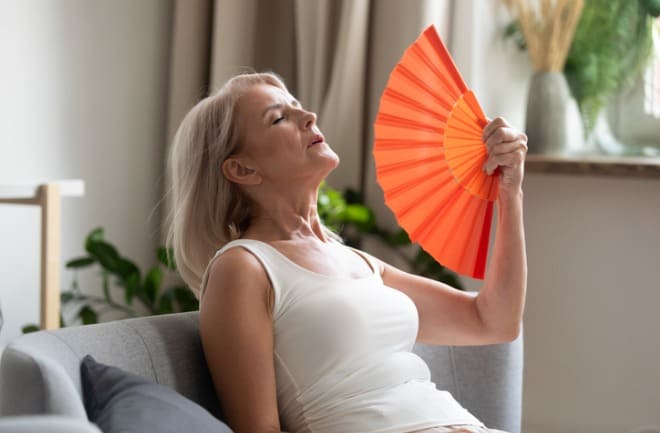 mulher sentindo sintomas da menopausa