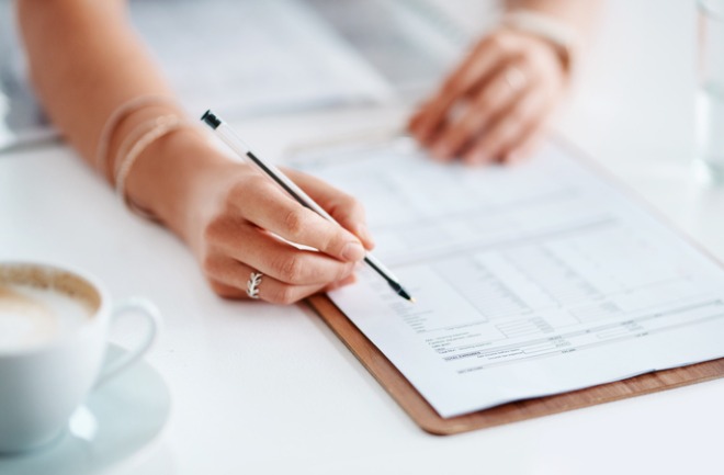 mulher analisando e assinando termos e condições de cirurgias plásticas.