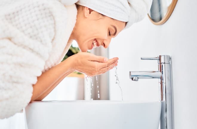 mulher lavando o rosto pós peeling facial
