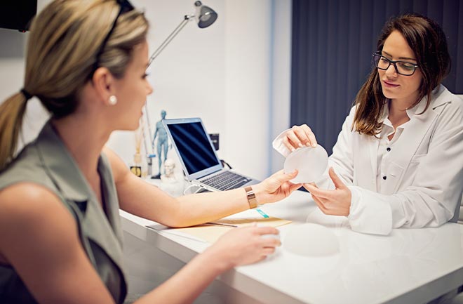 mulher na primeira consulta com cirurgião plástico tirando dúvidas sobre implantes mamários