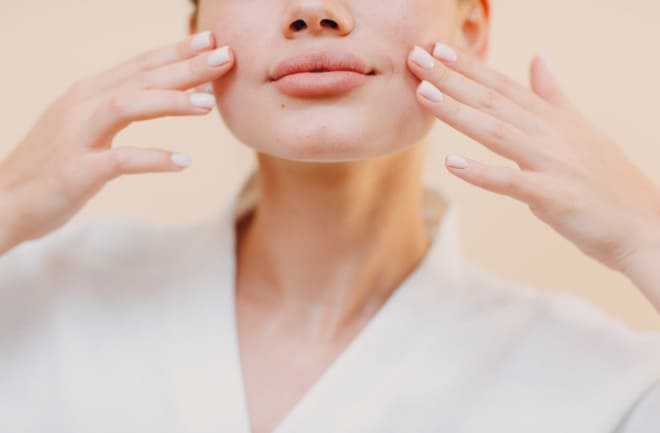 mulher realizando massagem facial