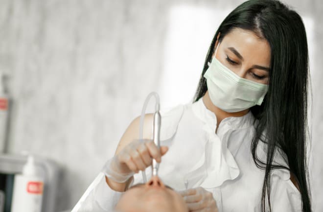 mulher realizando procedimento no couro cabeludo