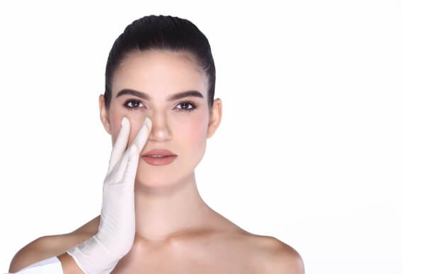 cirurgião plástico analizando nariz de mulher para uma rinoplastia