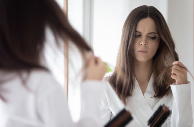 menina olhando seu cabelo cair